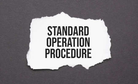 Standard Operation Procedure sign on the torn paper on the black backgroundの写真素材