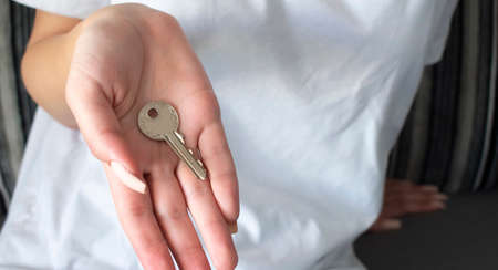 Female hand holding house key, real estate agent.の写真素材