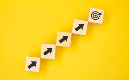 Virtual target board and arrow which print screen on wooden cube. Business achievement goal and...