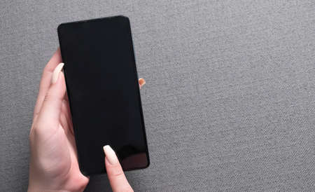 female hands holding phone with isolated screen in the house in room