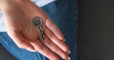 Hand holding house key of a property as a concept for house purchase and ownershipの写真素材