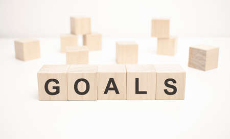 the word GOALS is written on a wooden cubes structure. blocks on a bright white background.の写真素材