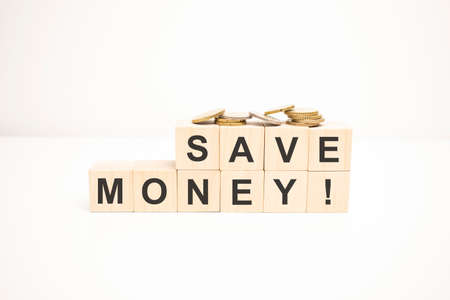 Coins on stack stair as step growing growth and wooden cube block with word save money. Money annual budget conceptの写真素材