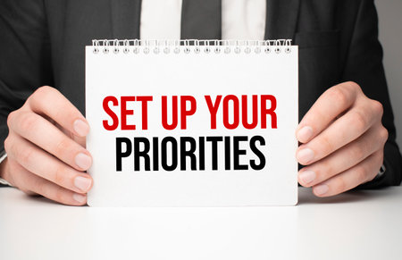 Businessman holding sheet of paper with a message Set up your prioritiesの写真素材