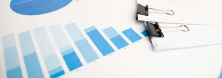 Pen, glasses and calculator on paper table with finance diagramの写真素材