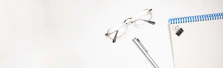 glasses, pen, notepad on the white backgroundの写真素材