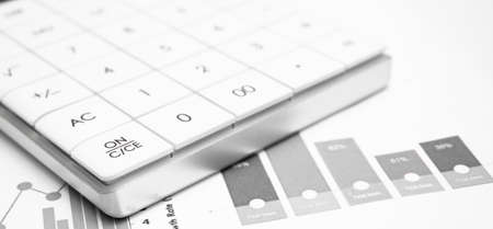 Calculator with pen on stock market analysis. Concept of Business, Finance and Audit research.