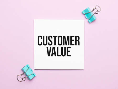 white paper with text customer value on a pink background with stationeryの写真素材