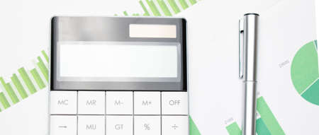 Financial charts and a calculator on the accountant's desk. Calculating profits, taxes, and paying...