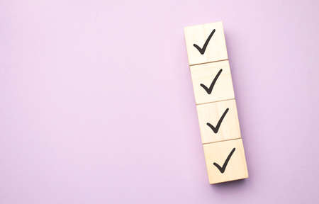 Checklist concept, Check mark on wooden blocks on table with copy spaceの写真素材