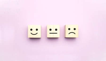 emotion face symbol on wooden cube blocks. Service rating, ranking, customer review, satisfaction and feedback conceptの写真素材