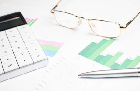 data analyzing in stock market: on the charts and quotes prints, the smart phone, eyeglasses and a penの写真素材