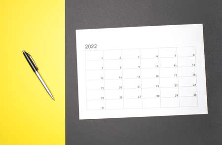 calendar month schedule to make appointment meeting or manage timetable each day lay and pen on yellow background for planning work and travel concept.の写真素材