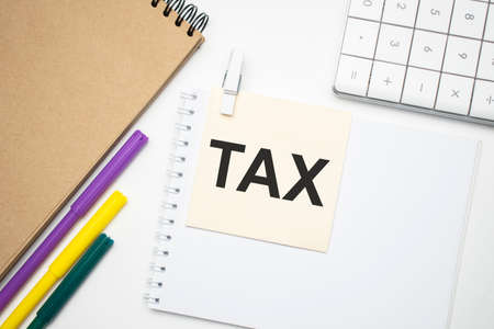 Tax Concept. Notebook on laptop keyboard, on light backgroundの写真素材