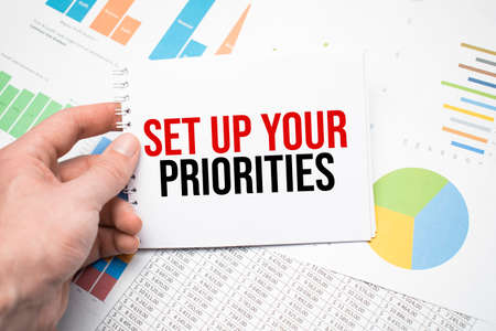 Set up your priorities on a notepad and financial documents and a cup of coffee on wood table.の写真素材