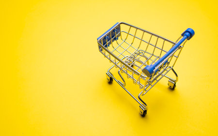shopping trolley on yellow background with some copy spaceの写真素材