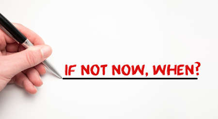 Hand writing if not now, when with red marker. Isolated on white background. Business concept.の写真素材