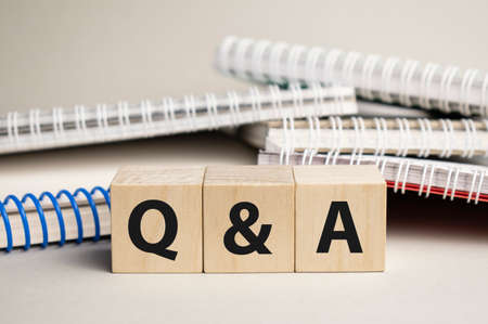 Q and A acronym on wood block cubes on wooden table over light blue gradient background, Frequently asked questions, Business customer service and support conceptの写真素材