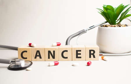 Text CANCER on wooden cubes on white textured putty background. Square wood blocks. Top view, flat lay.の写真素材