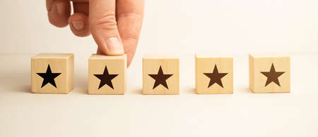 Man hand holding Star block. Customer choose rating for user reviews. Service rating, ranking,...