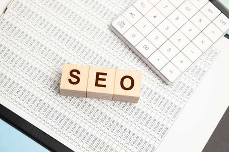 SEO - word composed on the wooden cubes with a calculatorの写真素材