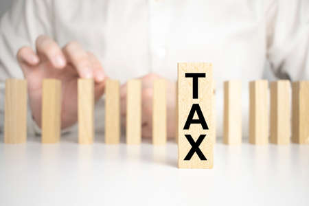 hand holding wood cube block with TAX text. Financial, management, economic, business conceptの写真素材
