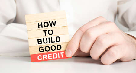 Build good credit symbol. Wooden blocks with words How to build good credit. light bulb icon....
