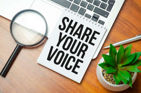 SHARE YOUR VOICE inscription on white paper note on laptop keyboard. closeup message.の写真素材
