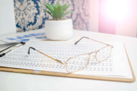 Glasses on the finance chart on the desk.