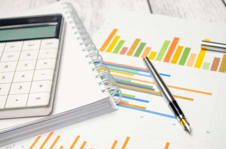 Notepad with pen and calculator on the paper graphs. business conceptの写真素材