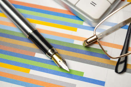 business objects - graphs, charts, pen and calculator on the tableの写真素材