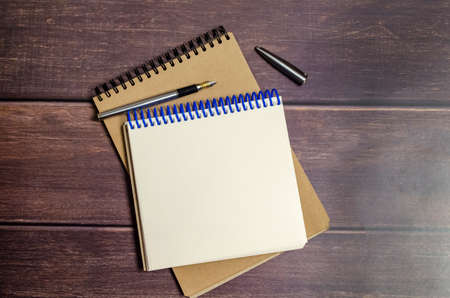 open notepads with pen on wooden background. business concept