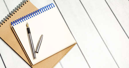 open notepads with pen on wooden background. business concept