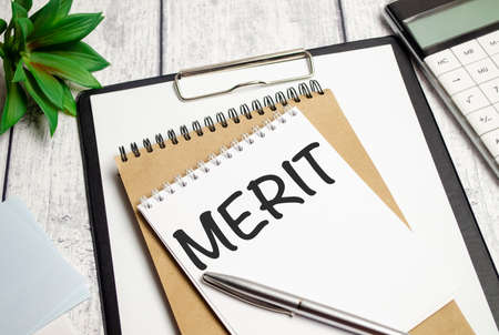 Word writing text MERIT on notebook and calculatorの写真素材