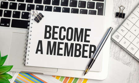 laptop charts, pen and a white notebook with the text BECOME A MEMBERの写真素材
