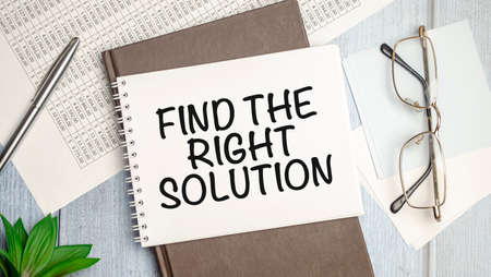 Find The Right Solution text on white notebook and pen on wooden backgroundの写真素材