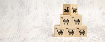 Business sale growth and expand shop franchise concept, wooden cube block which print screen chart and shopping trolley cart on table.の写真素材