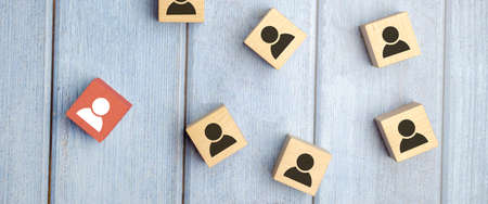 wooden cube blocks with printed blue human symbol. Leadership and team building concept