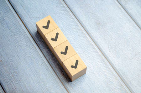 Checklist concept, Check mark on wooden blocks, blue background with copy spaceの写真素材