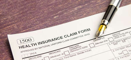 health insurance concept with pen on wooden background