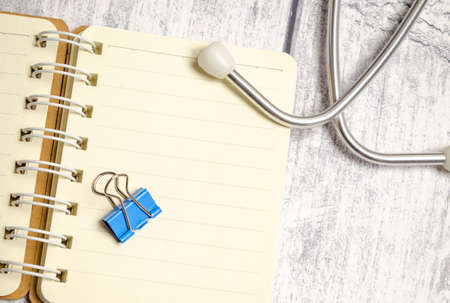 Workplace of doctor - stethoscope, medicine notepad on wooden desk