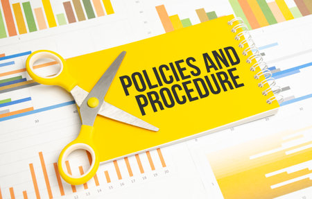 policies and procedure word written on yellow notebook and chartsの写真素材