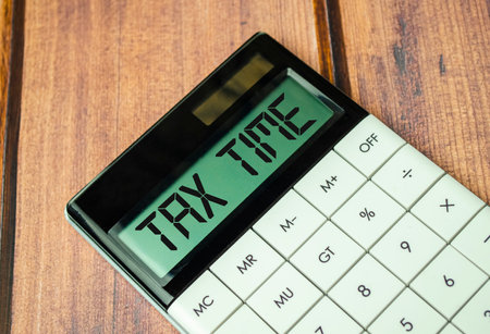A calculator with text Tax Time on the displayの写真素材