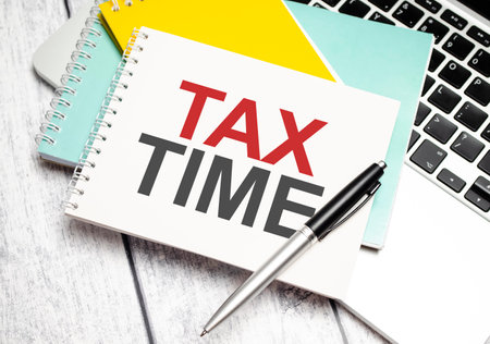 tax time word with laptop and notebooksの写真素材