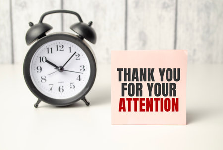 The words Thank Your For Your Attention on alarm clock and wooden backgroundの写真素材