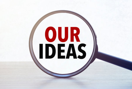 Magnifying glass with text our ideas on wooden table.の写真素材