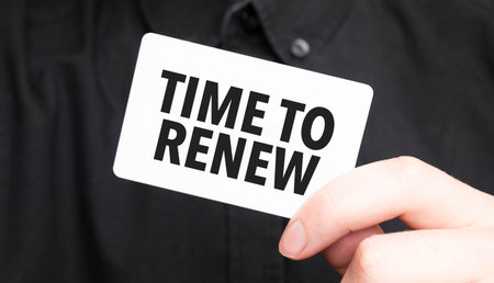 Businessman holding a card with text time to renew, business conceptの写真素材