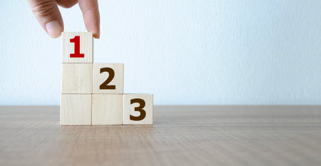 Task priority and management concept, Hand arranging Wooden cube blocks with number first, second, thirdの写真素材