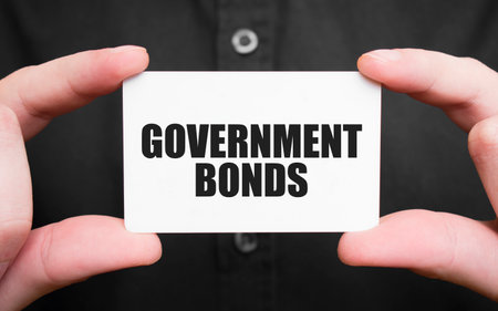 Businessman holding a card with text GOVERNMENT BONDS, business conceptの写真素材
