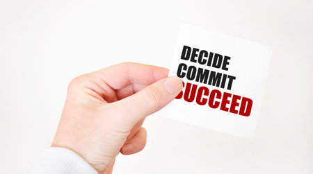 Businessman holding a card with text DECIDE COMMIT SUCCEED ,business conceptの写真素材